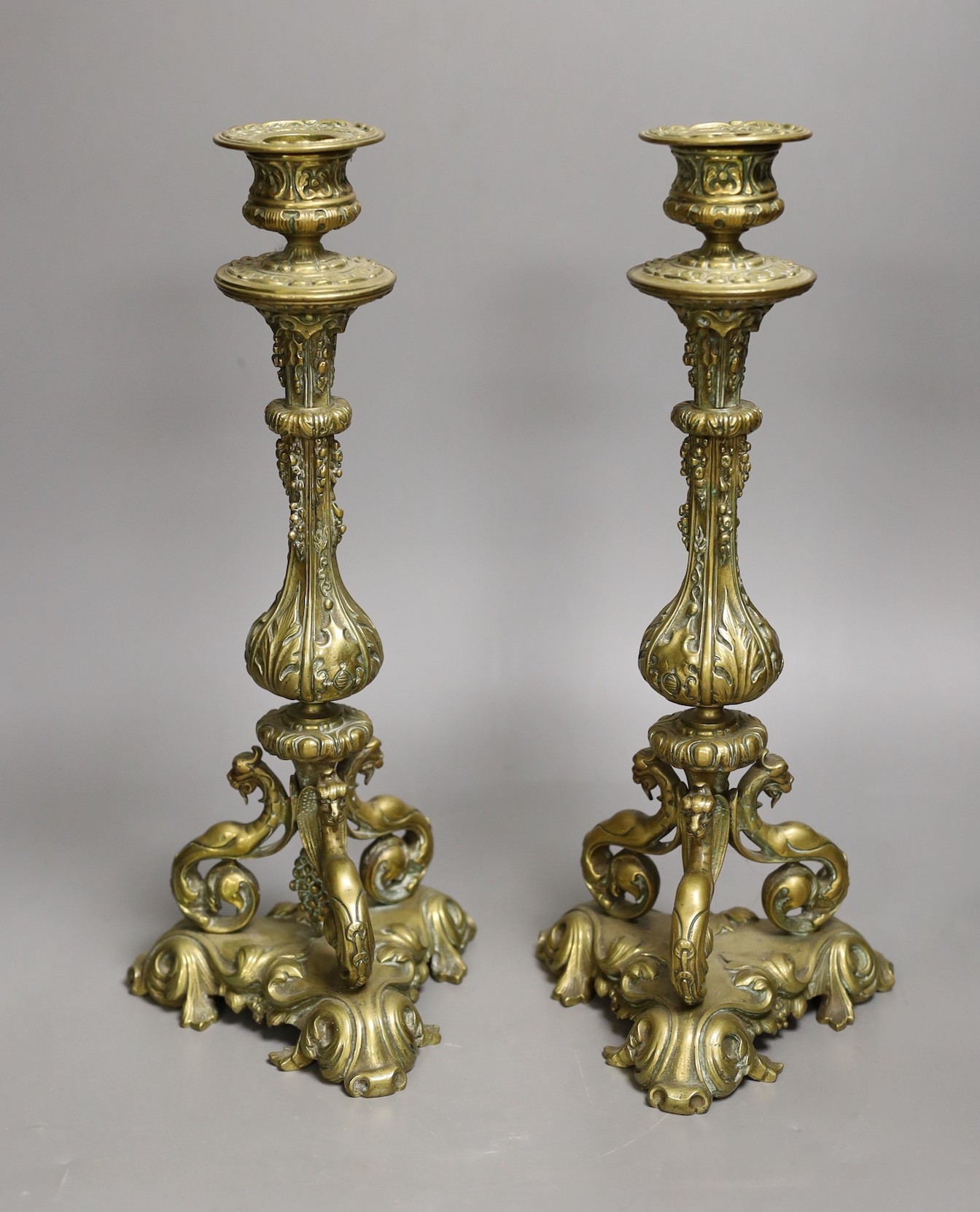 A pair of 19th century ornate brass candlesticks, 31cms high